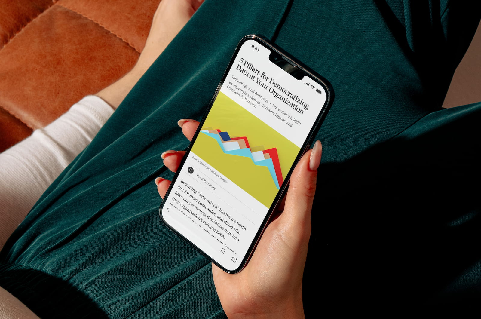 Woman holding a phone with the HBR app on it.